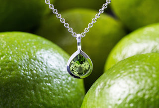 Alt-Text: Grüner Peridot-Anhänger in Tropfenform von Bastian Inverun, polierte Fassung auf strichmattiertem 925 Sterlingsilber