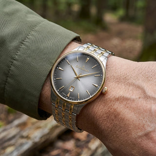 Dugena Grace mit anthrazitfarbenem Zifferblatt und Bicolor-Armband am Handgelenk zu grünem Ärmel